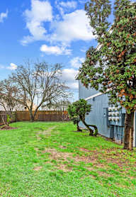 A blue house with a green bush in front.