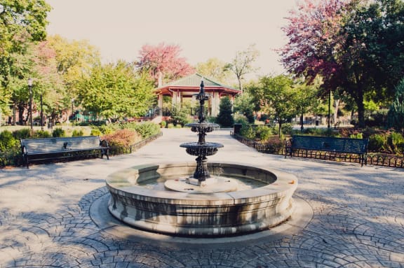 a fountain in a park with benches and a gazebo at 100 House Apartments, Jersey City , New Jersey