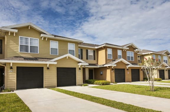 a row of houses with garages and a sidewalk