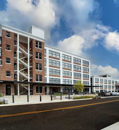 a rendering of a large apartment building on a city street