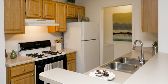 a kitchen with white appliances and wooden cabinets