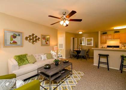 a living room with a couch coffee table and a ceiling fan