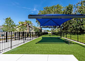 Thumbnail 4 of 6 - A park with a blue canopy and a bench.