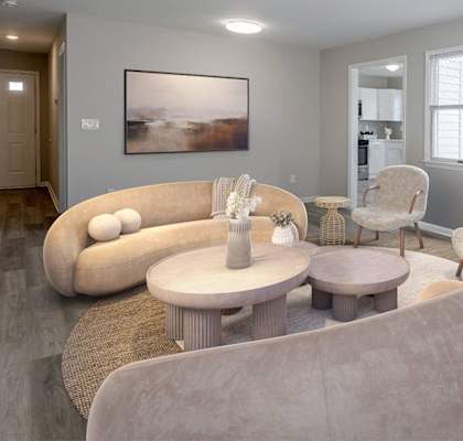 A living room with a large couch, two chairs, and a coffee table.