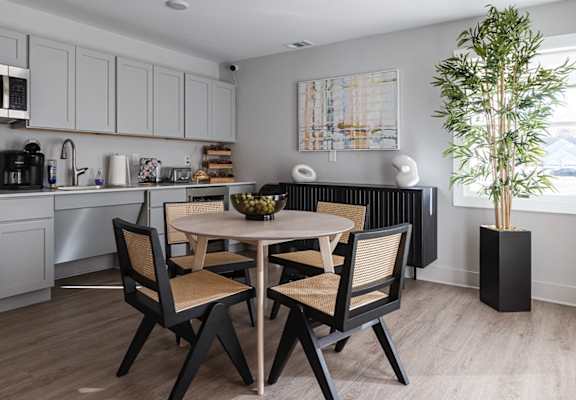 A modern kitchen with a dining table set for two.