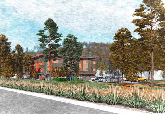 A road with a building and trees on the side.