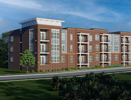 A row of red brick apartment buildings with green lawns in front.