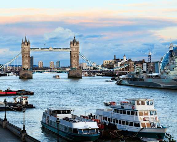 A boat is docked near the London Bridge.
