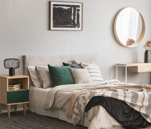 a bedroom with a bed and a mirror on the wall