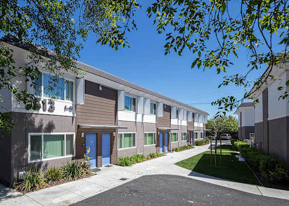 a picture of a building with blue doors and brown and white siding at MEADOWS HOLLY, VACAVILLE, 95688