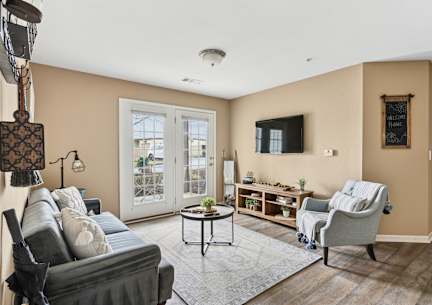 A living room with a grey couch, a coffee table, a chair, and a lamp.