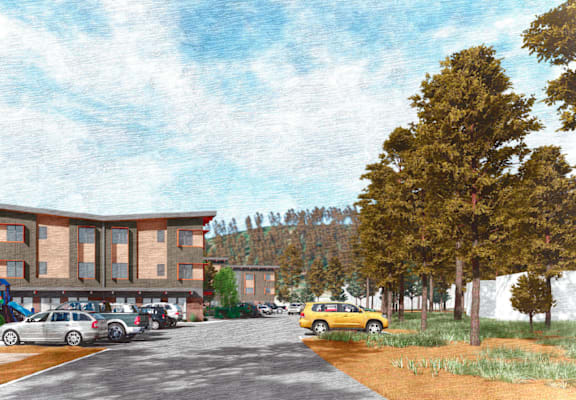 A parking lot with cars and a yellow taxi in front of a building.