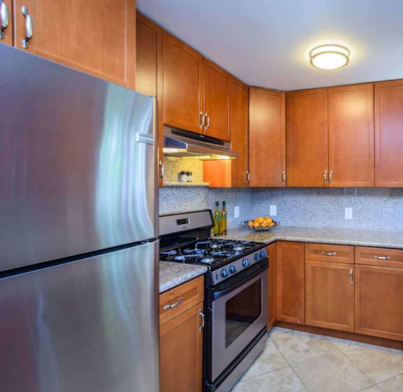 A kitchen with wooden cabinets and granite countertops.