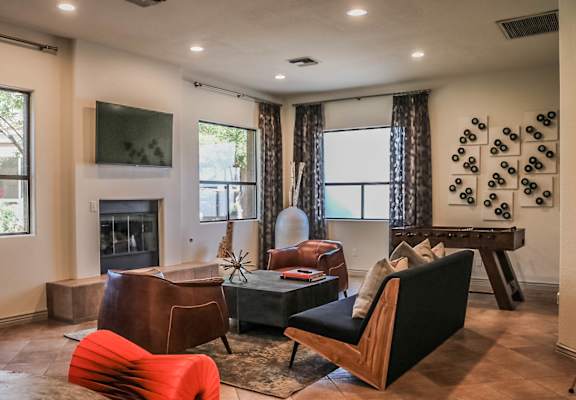 a living room with a fireplace and chairs and a table