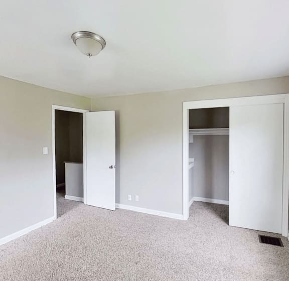 A room with two white doors and a ceiling light.