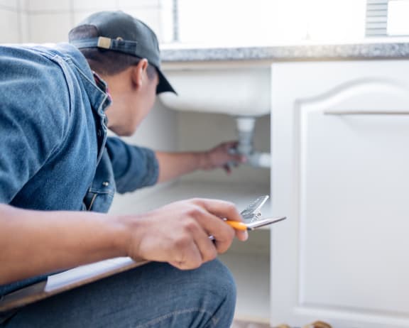 a man plumbing a bathroom sink with a pair of scissors