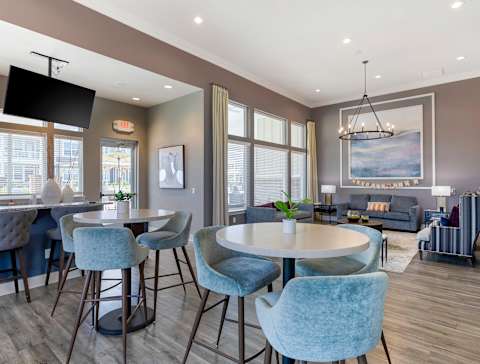 A modern dining room with a round table and blue chairs. at The Villas at Germantown, Memphis, TN, 38125