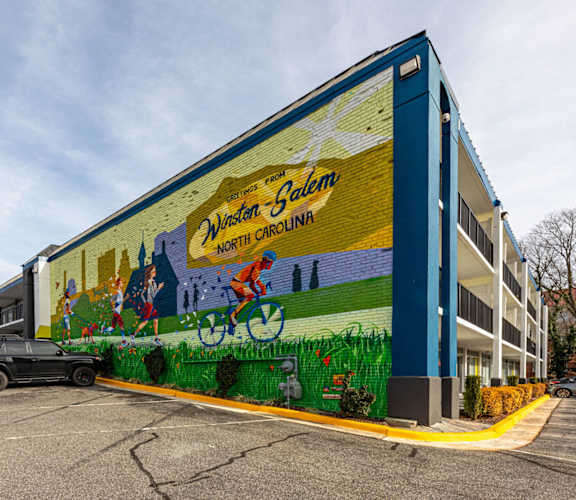 a mural on the side of a building in a parking lot