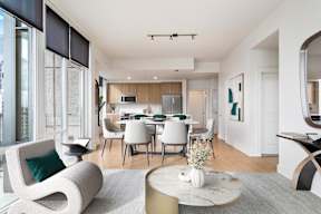 A modern living room with a dining table and chairs.