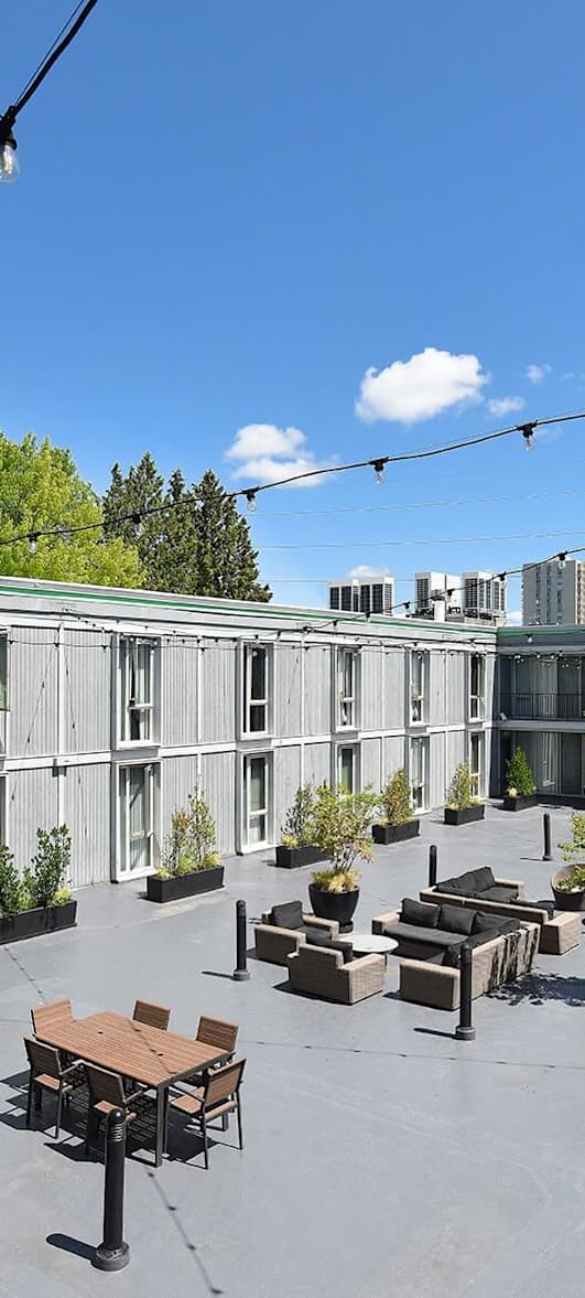 the patio of the building has tables and chairs and plants