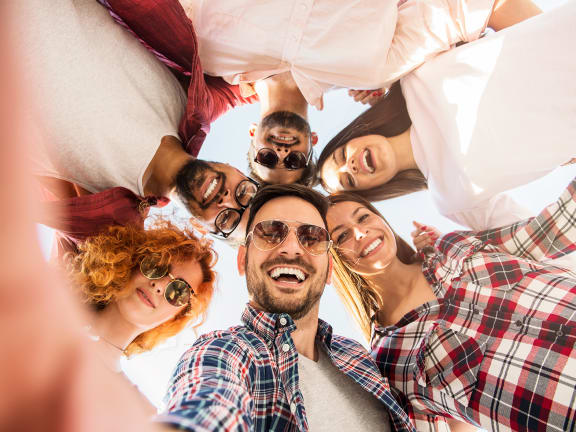 a group of people standing in a circle with their heads together