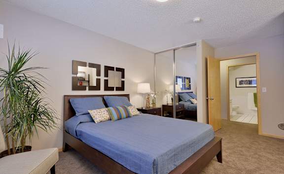 a bed with a closet and a door leading into a bathroom