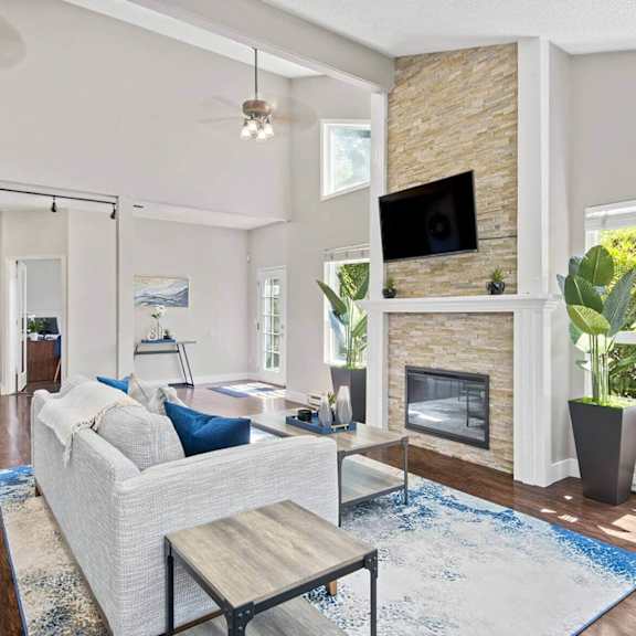 A living room with a white couch and a fireplace.