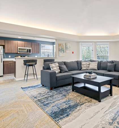 A modern living room with a grey sofa and a coffee table.