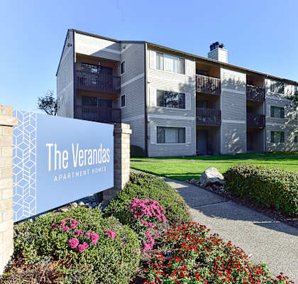 The Verandas Apartment Homes building with a blue sign in front of it.
