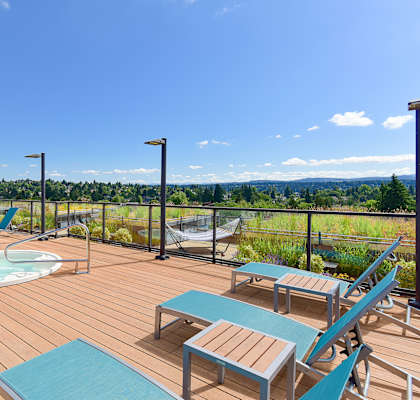 a deck with a hot tub and lounge chairs