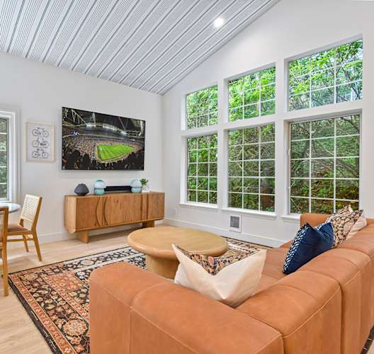 A living room with a tan couch, a wooden chair, and a rug. at Lakemont Orchard Apartments, Washington, 98027