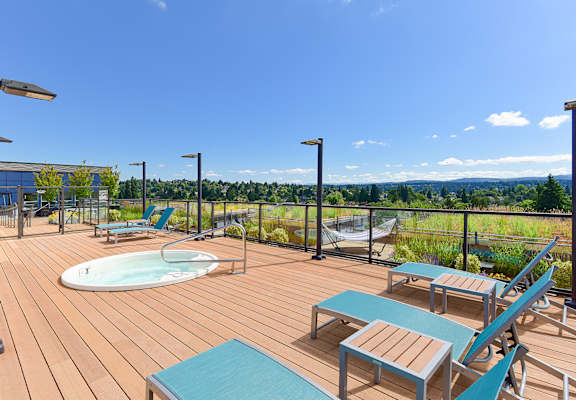 a deck with a hot tub and lounge chairs