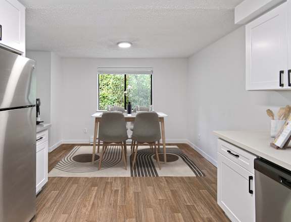 a kitchen with a table and chairs in front of a window