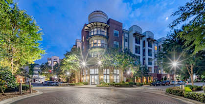a city street with buildings and trees at night at The Haven, Atlanta Georgia