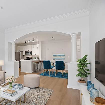 A living room with a beige couch, a coffee table, and a painting on the wall.