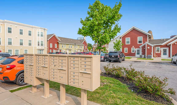 a mailbox on a post in front of a parking lot