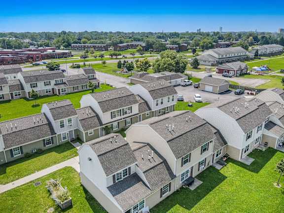 A bird's eye view of a residential area with houses and green lawns.