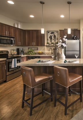 a kitchen and living room with hardwood floors and a large island with a granite countertop