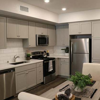a kitchen with white cabinets and stainless steel appliances