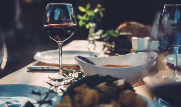 a table with plates of food and a glass of wine