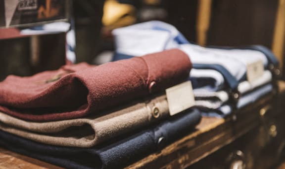 a pile of folded clothes on top of a suitcase