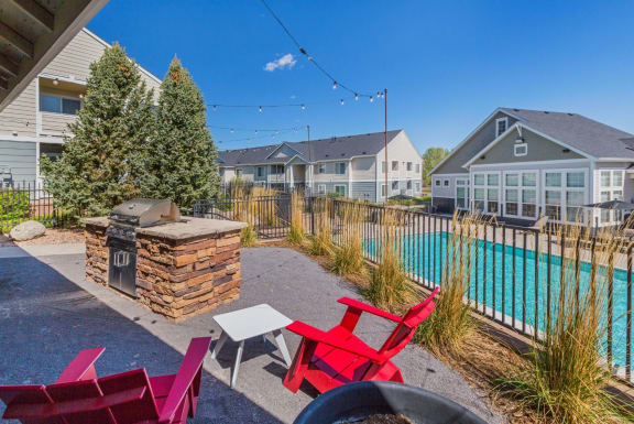 A backyard with a pool and a stone fireplace. at The Village at Westmeadow, Colorado, 80906
