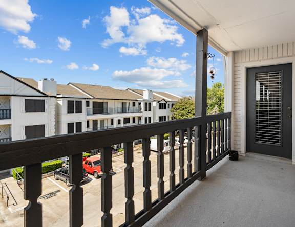 the view from the balcony of a home with a black railing and a door