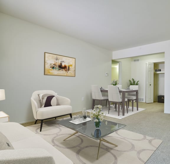 a living room and dining room with a table and chairs at Perry Place Apartments, Grand Blanc, Michigan