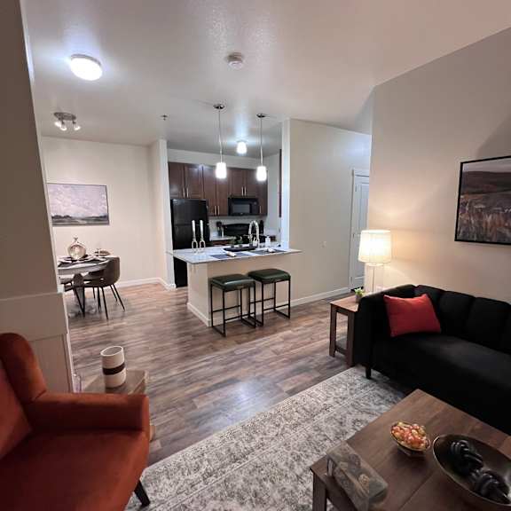 A living room with a black couch and a wooden coffee table.