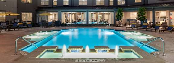 A large house with a pool in front.