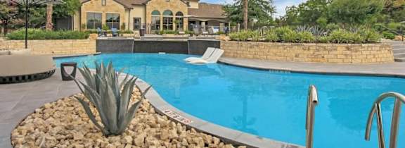 A large house with a pool in front.