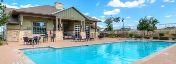 A large house with a pool in front.