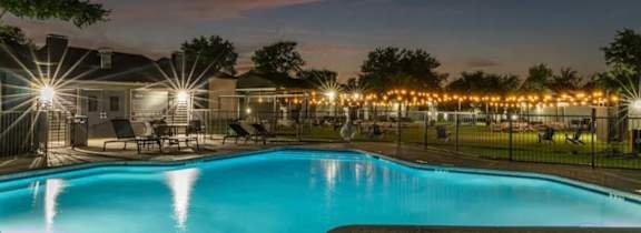 A large house with a pool in front.