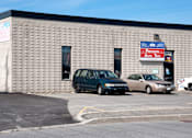 Thumbnail 4 of 6 - Two cars are parked in front of a building with a sign that says Precision Auto Tech.